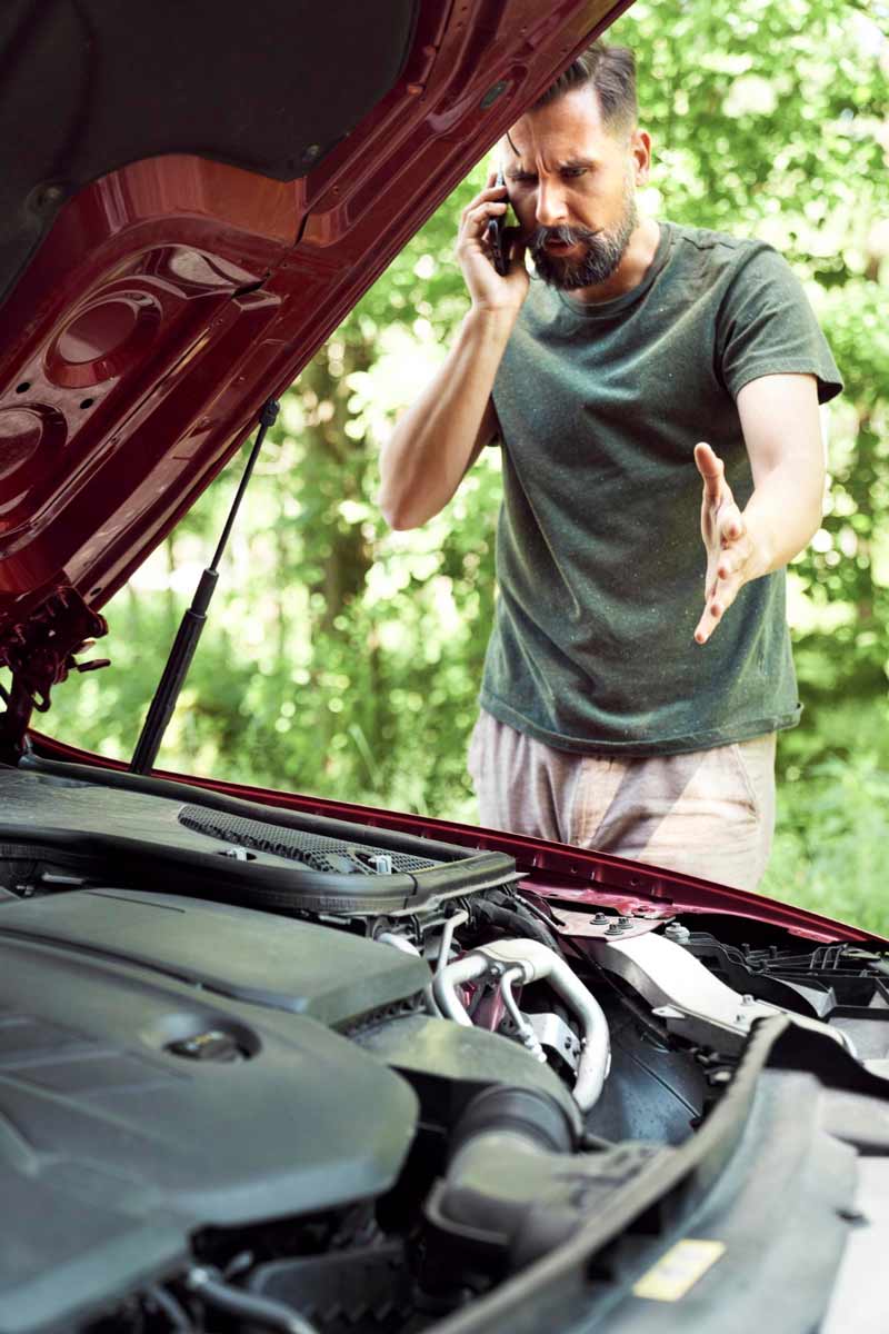 Junger Mann prüft Getriebeschaden bei Schrottauto Ankauf Bornheim